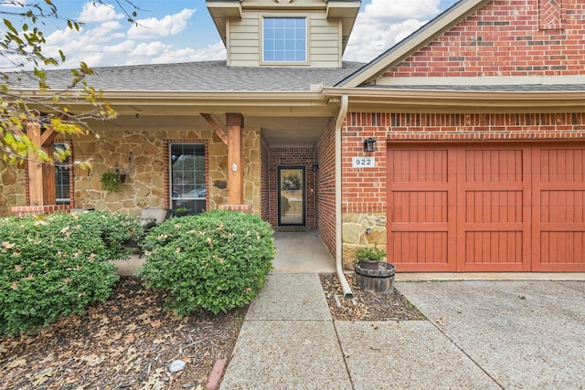 doorway to property featuring driveway, stone siding, brick siding, and roof with shingles