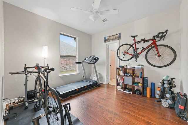 workout area featuring ceiling fan, visible vents, and dark wood-style flooring