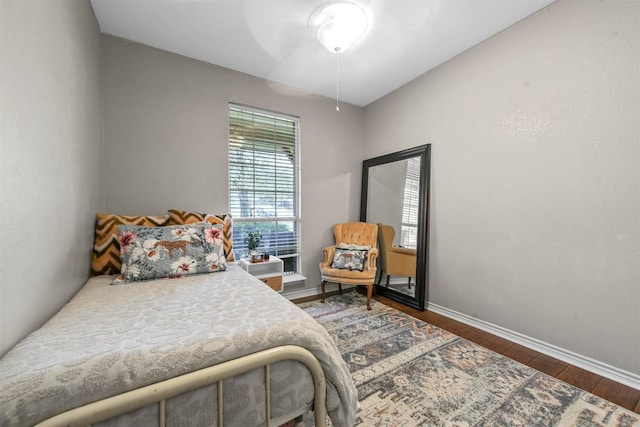 bedroom featuring baseboards and dark wood-style flooring