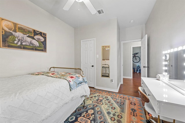 bedroom featuring dark wood-type flooring, a ceiling fan, visible vents, and baseboards