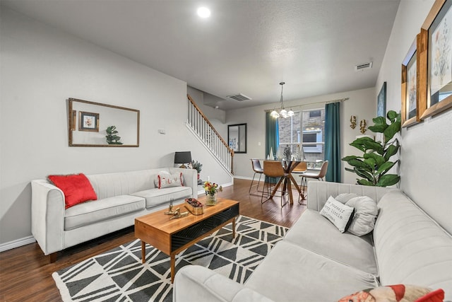 living area featuring stairway, dark wood finished floors, visible vents, and baseboards