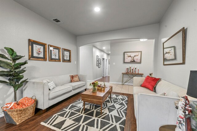 living area with visible vents, arched walkways, dark wood-style flooring, and recessed lighting