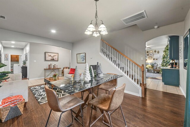 dining area featuring stairs, wood finished floors, washing machine and dryer, and visible vents