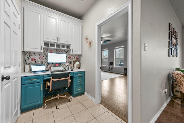 home office with ceiling fan, light tile patterned flooring, and baseboards