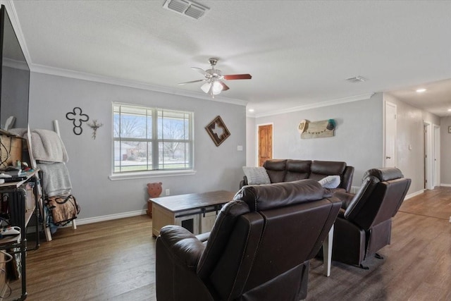 living room with hardwood / wood-style flooring, ornamental molding, and ceiling fan