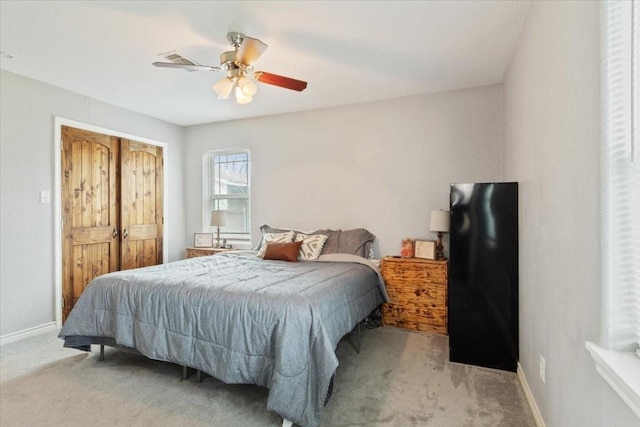 bedroom featuring ceiling fan, light colored carpet, and a closet