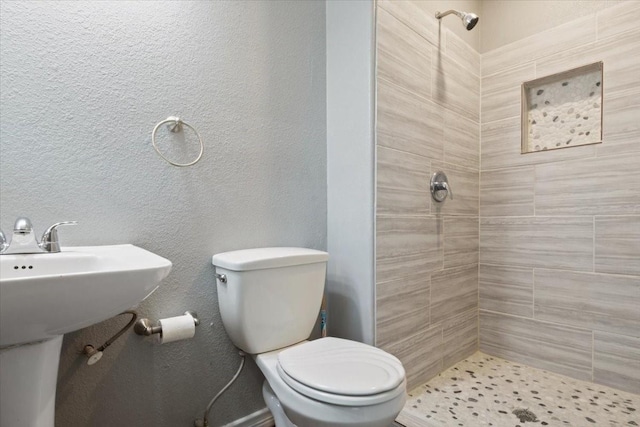 bathroom with tiled shower and toilet