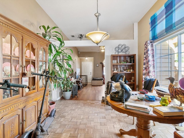 office area with ceiling fan, light parquet floors, and vaulted ceiling