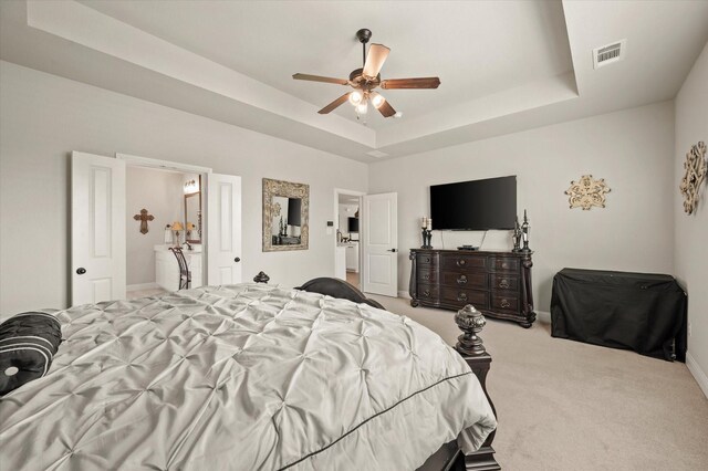 carpeted bedroom featuring ceiling fan and a tray ceiling