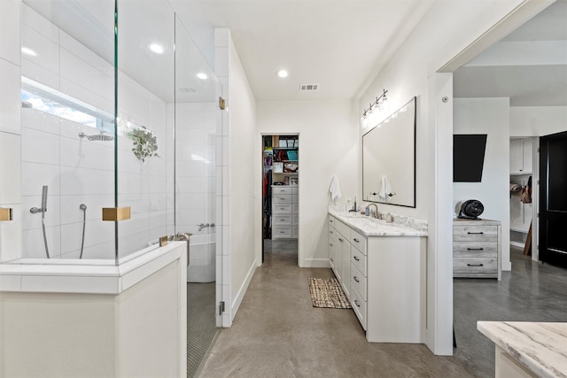 353 Willow Moon Ranch Rd, Crawford, TX 76638 - bathroom with finished concrete flooring, tiled shower, vanity, a walk in closet, and recessed lighting