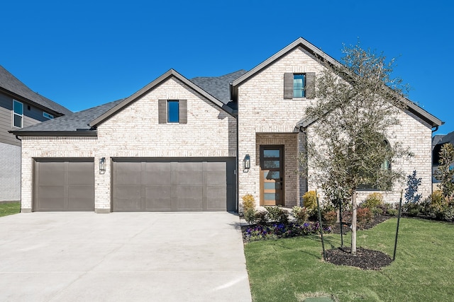 view of front of home with a garage and a front lawn