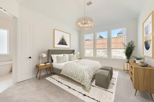 bedroom featuring light carpet and a chandelier