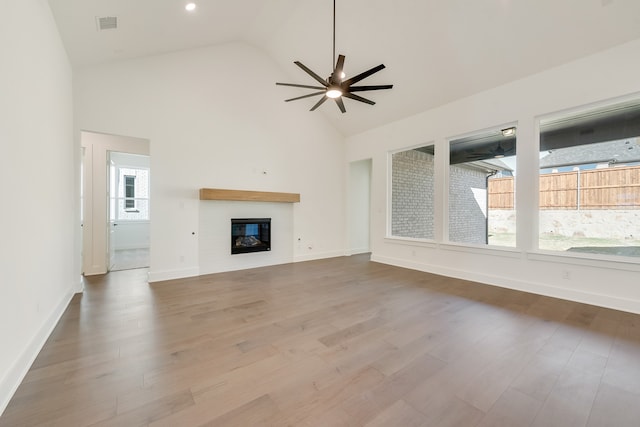 912 Shady Oaks Dr, Rockwall, TX 75087 - unfurnished living room with high vaulted ceiling, a glass covered fireplace, ceiling fan, and wood finished floors
