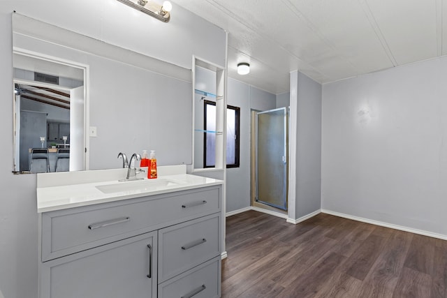 bathroom with wood-type flooring, vanity, and an enclosed shower