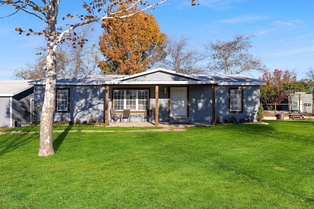 rear view of property with a lawn and a patio