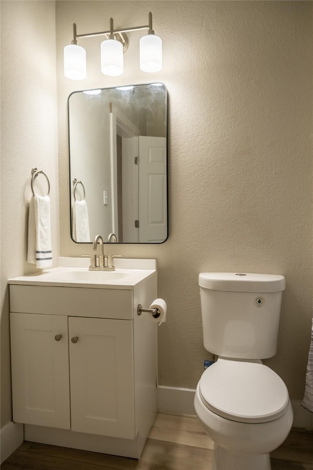 bathroom featuring hardwood / wood-style floors, vanity, and toilet