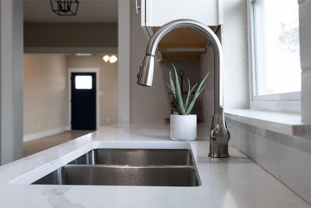 room details featuring light stone countertops and sink