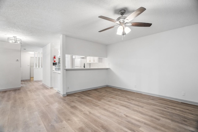 unfurnished living room with light hardwood / wood-style floors and a textured ceiling