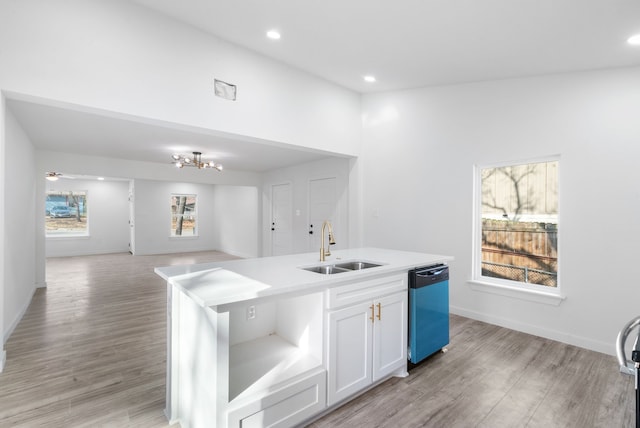 kitchen featuring white cabinets, dishwasher, plenty of natural light, and an island with sink