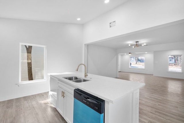 kitchen with light wood-type flooring, white cabinets, sink, dishwasher, and an island with sink