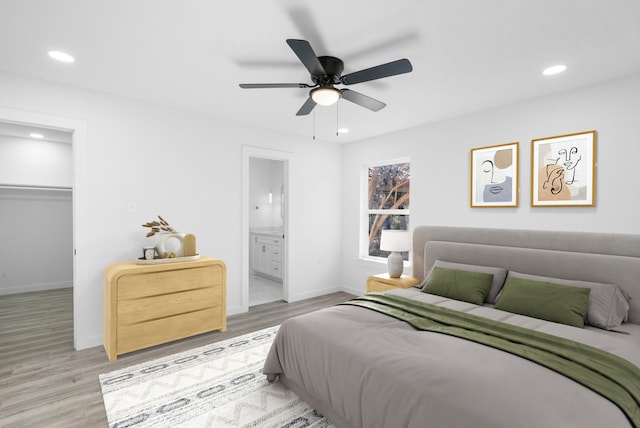 bedroom featuring light wood-type flooring, a closet, ensuite bath, and ceiling fan