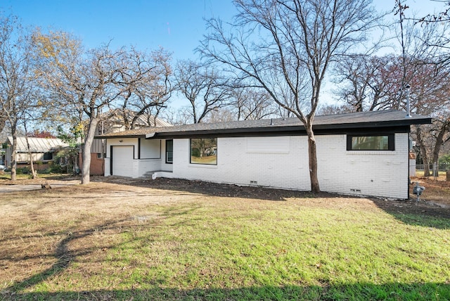 ranch-style house featuring a garage and a front lawn