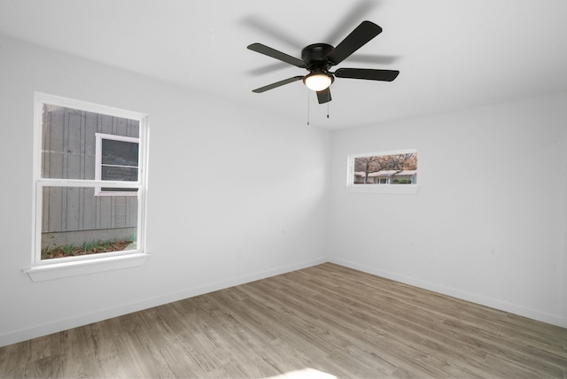 unfurnished room with light hardwood / wood-style floors, ceiling fan, and a healthy amount of sunlight