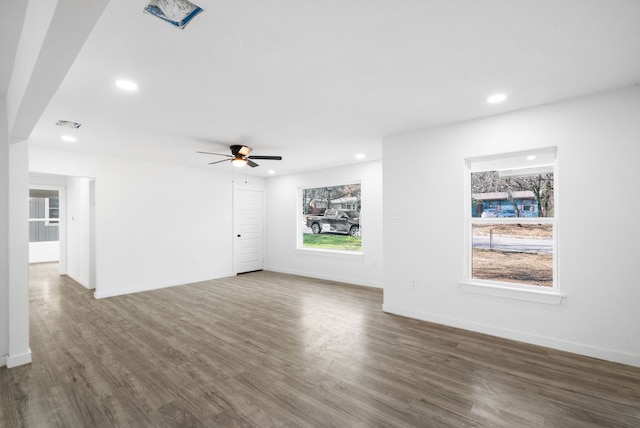 unfurnished living room with ceiling fan and dark wood-type flooring