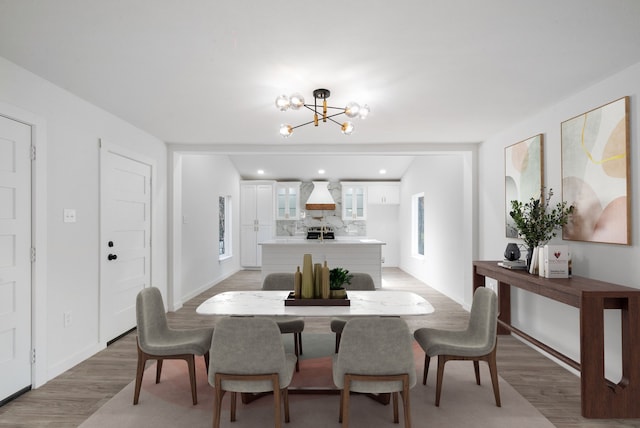 dining space with light hardwood / wood-style flooring and a chandelier