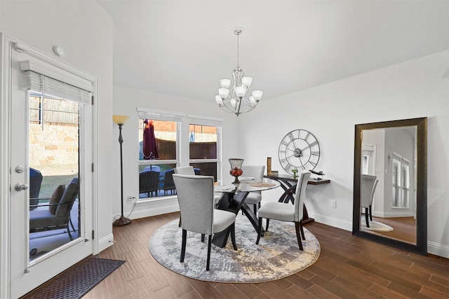 dining room with dark hardwood / wood-style floors and an inviting chandelier