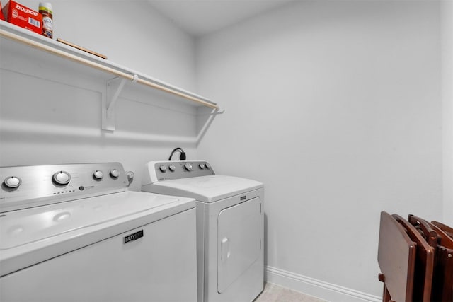 laundry room with washer and clothes dryer and light tile patterned floors