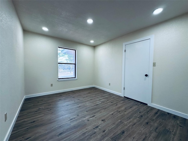 unfurnished room featuring dark wood-style floors, recessed lighting, and baseboards