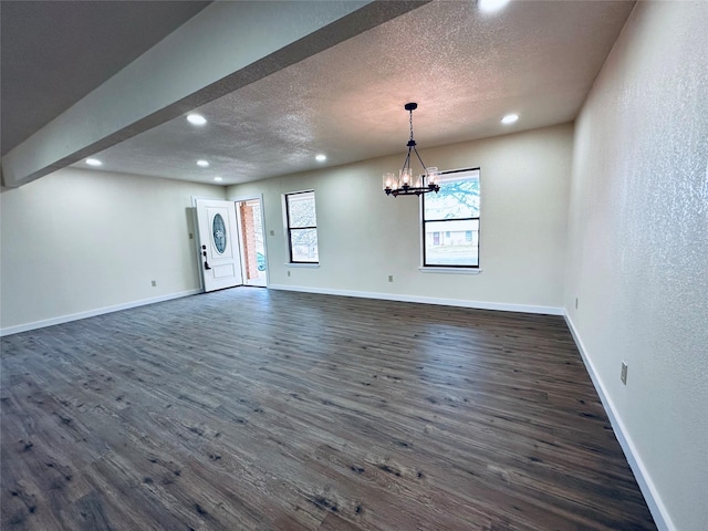 unfurnished room with dark wood finished floors, a textured ceiling, and baseboards