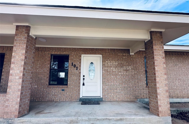 view of exterior entry featuring brick siding