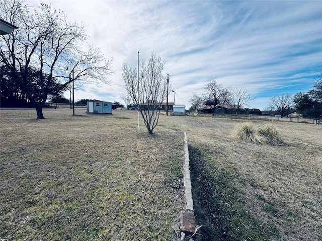 view of yard featuring an outdoor structure and a storage shed