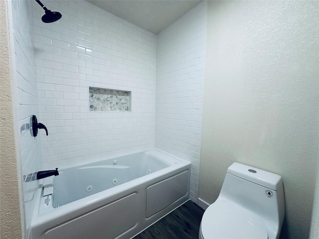 bathroom with baseboards, a textured wall, toilet, and wood finished floors