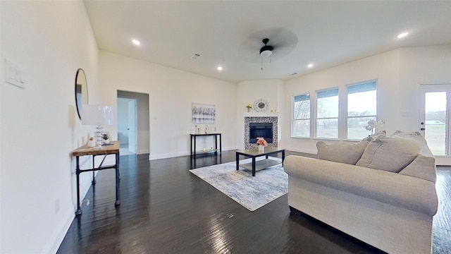 living room with a fireplace, dark hardwood / wood-style floors, and ceiling fan