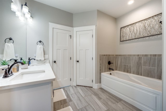 bathroom featuring a bath, vanity, and hardwood / wood-style flooring