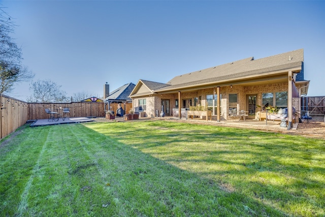 rear view of property featuring a patio area and a lawn