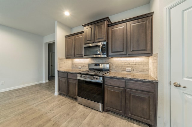 kitchen featuring dark brown cabinetry, stainless steel appliances, tasteful backsplash, and light hardwood / wood-style floors