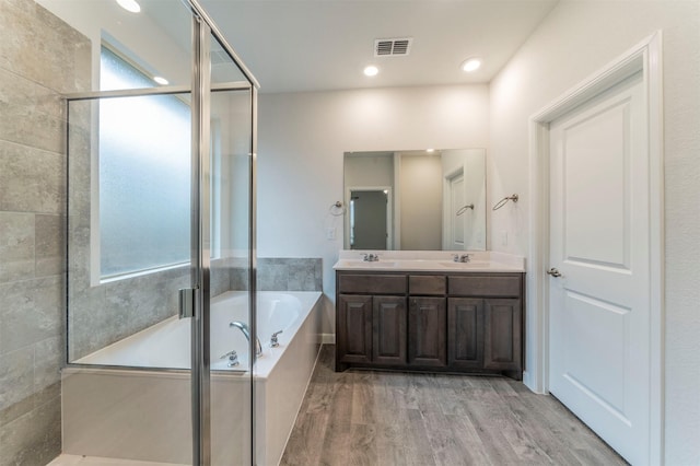 bathroom featuring hardwood / wood-style floors, vanity, and shower with separate bathtub