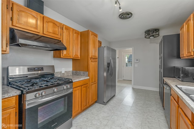 kitchen with sink, light tile patterned floors, and stainless steel appliances