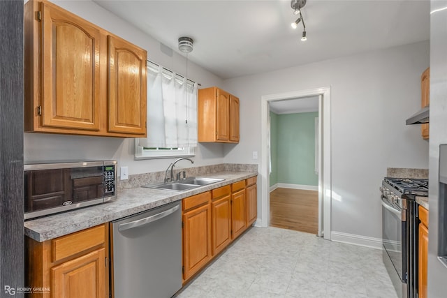 kitchen with appliances with stainless steel finishes, ventilation hood, hanging light fixtures, and sink