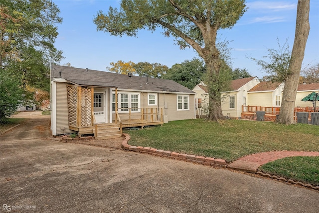 back of house featuring a deck and a lawn