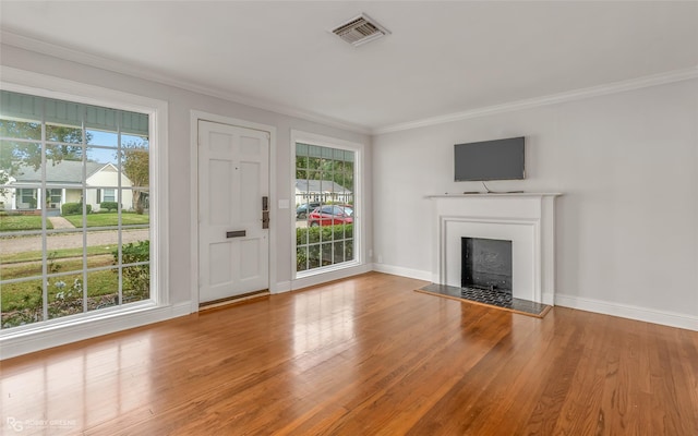 unfurnished living room with hardwood / wood-style floors and crown molding