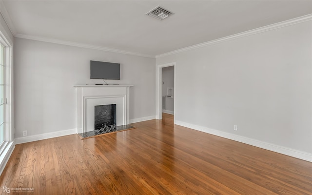 unfurnished living room featuring a healthy amount of sunlight, wood-type flooring, and crown molding