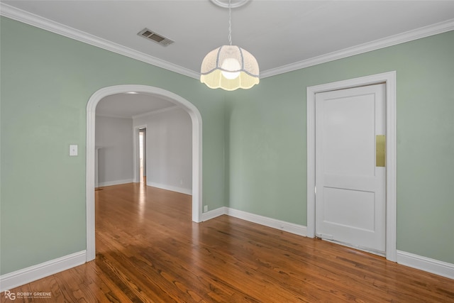 empty room featuring hardwood / wood-style floors and crown molding