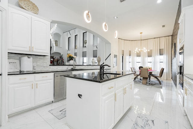 kitchen featuring tasteful backsplash, stainless steel appliances, pendant lighting, white cabinets, and a center island