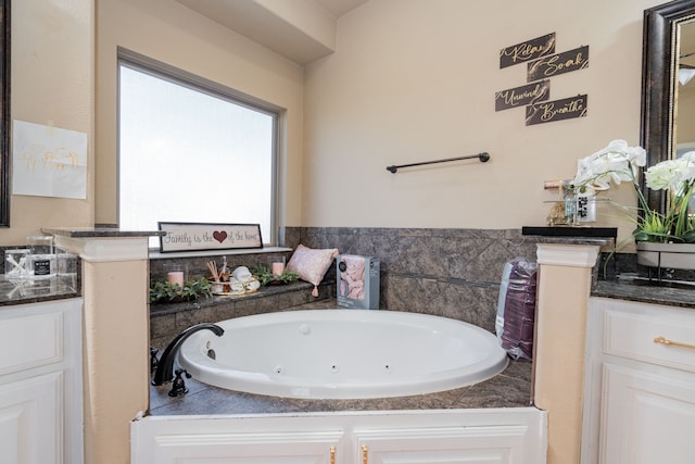 bathroom with a tub to relax in and vanity