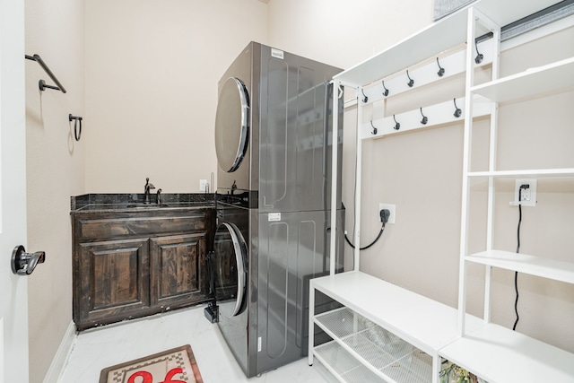 bathroom featuring stacked washer / dryer and sink